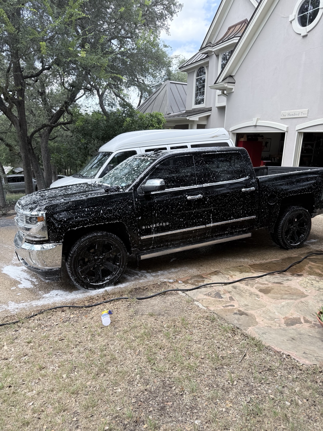 Black Chevrolet Silverado during foam pre-soak side angle